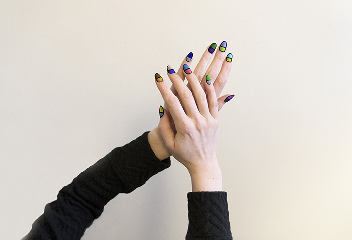 two hands display nails with the color system used by x-rite to color correct photos